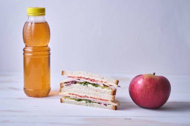 Okul kahvaltısı. Meyve suyu, sandviç ve elma..