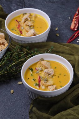 Kabak kremalı çorba, ekmek kırıntıları, acı biber ve kekik, balkabağı tohumlarıyla süslenmiş..