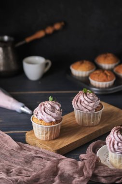 Pembe kremalı tatil kekleri. Tatlı nane yaprakları ve çikolata parçacıklarıyla süslenmiş. Kekler ve kahve. Arkaplan rengi klasik mavi.
