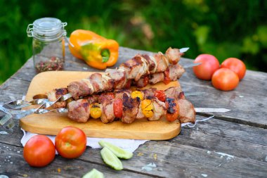 Ahşap bir masada taze pişmiş barbekü. Doğada yaz yemeği. Lezzetli et yemeği ateşte pişmiş..