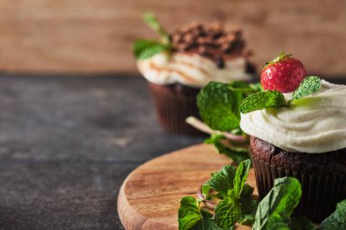 Kremalı kekler, taze böğürtlen, çikolata ve naneli, kakaoyla süslenmiş.