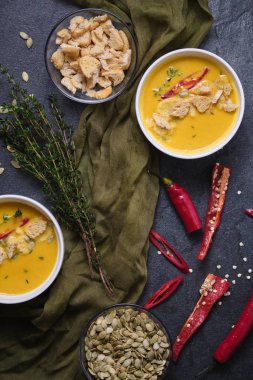 Kabak kremalı çorba, ekmek kırıntıları, acı biber ve kekik, kabak çekirdeğiyle süslenmiş. Üst görünüm.