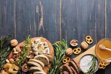 Lezzetli atıştırmalıklar. Eski ahşap bir masada çeşitli peynir, fındık, ciabatta ve sosis çeşitleri. Romantik bir yemek için yemek. Üst Manzara. Metin için yer.