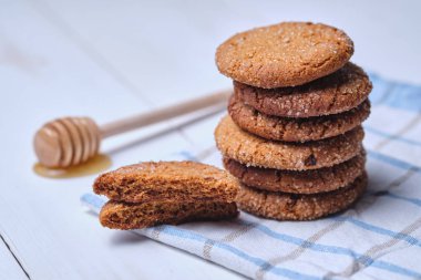 Ballı yulaflı kurabiye kulesi. Havlunun üzerinde tatlı, yakın plan beyaz bir masada..
