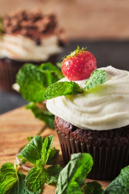 Kremalı kekler, taze böğürtlen, çikolata ve naneli, kakaoyla süslenmiş.