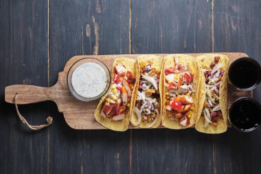 Eski ahşap bir masada etli ve sebzeli Meksika tacoları. Öğle ve akşam yemeği için hızlı sokak yemekleri.