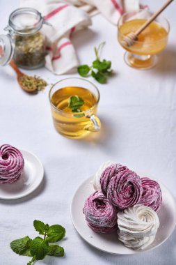 Ballı, naneli ve ev yapımı böğürtlenli çay. Keten masa örtüsü üzerinde lezzetli ve sağlıklı bir kahvaltı. Çilek üzümlü lokum..