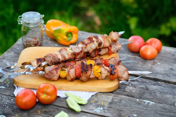 Ahşap bir masada taze pişmiş barbekü. Doğada yaz yemeği. Lezzetli et yemeği ateşte pişmiş..