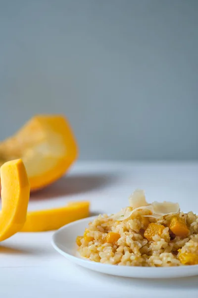Balkabağı kapaklı risotto. Beyaz masada İtalyan yemeği..