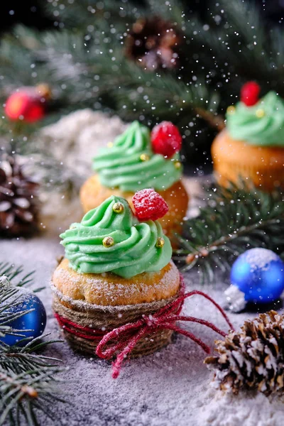 Snowfall from powdered sugar. Christmas cupcakes in a festive and snowy forest. Dessert for New Year and Christmas celebration.