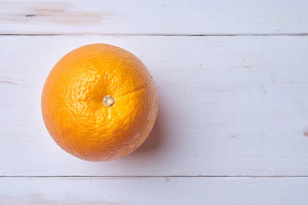 Orange on a white wooden table. Place for text.