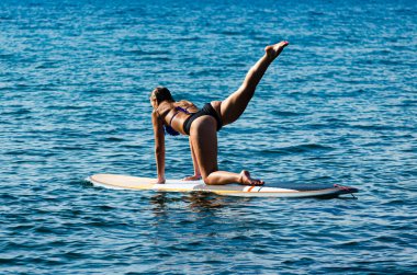 Seksi bir kadın, yoga pozu veriyor.