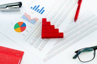 Harcamalar, sermaye veya aktifler için bir kavram olarak kırmızı küpleri bir sütun grafiğinde düzenlenmiş mali belgeler