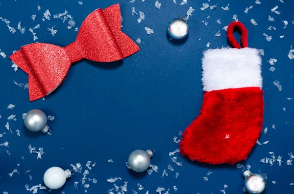 Çoraplar, fiyonk ve süsler Noel tatilinin kavramsal bir görüntüsü. Kırmızı ve beyaz dekorasyonlar mavi arkaplanda kopyalama alanı ile.