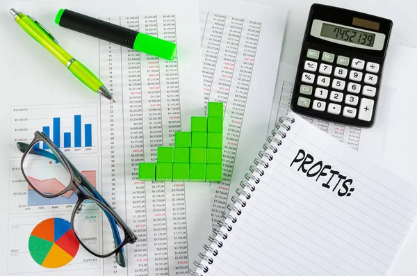 Finanzdokumente, mit grünen Würfeln in einem Spaltendiagramm angeordnet — Stockfoto