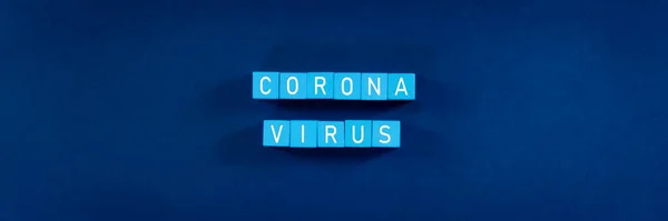 Word corona virus  spelled in white text on light blue blocks in a conceptual image of corona virus outbreak.