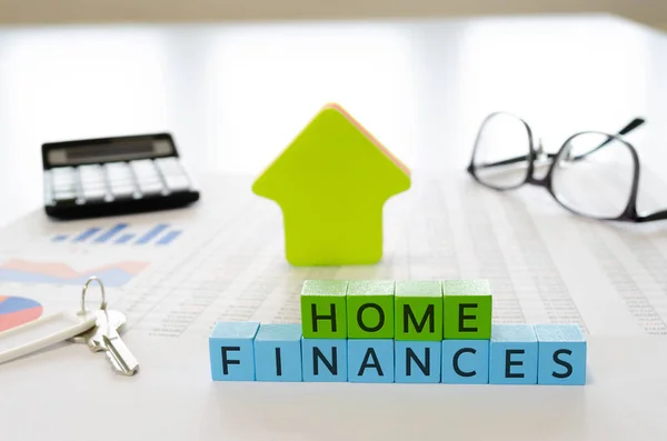 Ev ekonomisi. Hesap makinesi, anahtar ve gözlüklü çizelgelerin yan görüntüsü. Ev finansmanı kavramı