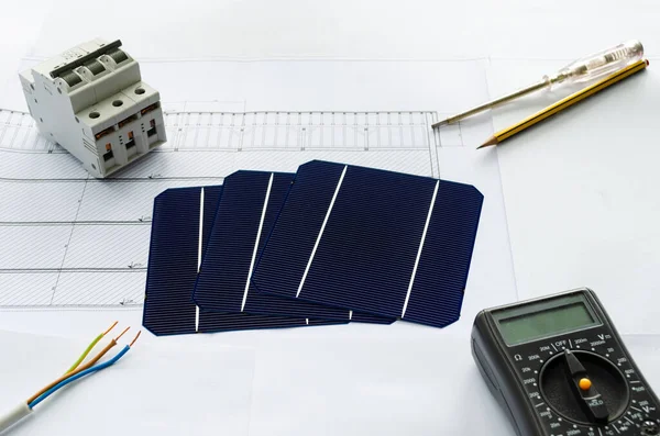 Güneş pillerinin üst görünümü, kırıcı, tornavida, kalem, elektrik kablosu ve voltametre fotoğraf voltaik projesini planlama konsepti olarak gösterilir