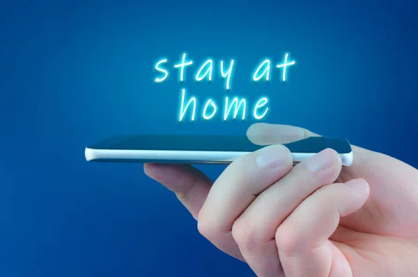 Bir elin üzerinde süzülen neon levhada kal. Kavramsal izolasyon görüntüsünde akıllı bir telefonu tut. Coronavirüs 'ün Covid 19' un tecridi sırasında yayılmasını önlemek için ev karantinası yap.