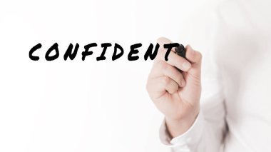 Bir iş adamının eli, verimlilik ve performansın kavramsal görüntüsüne sahip siyah kalemle kendine güvenen bir kelime yazıyor.