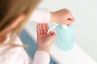 Küresel virüs salgınında el dezenfektanı kullanan küçük bir kızın en iyi görüntüsü.