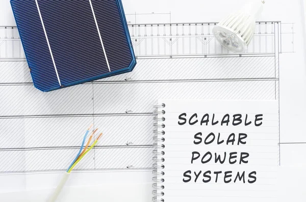 Solar cells, wires and led bulb note pad with Scalable Solar Power Systems written on it in a conceptual image to scale solar power production