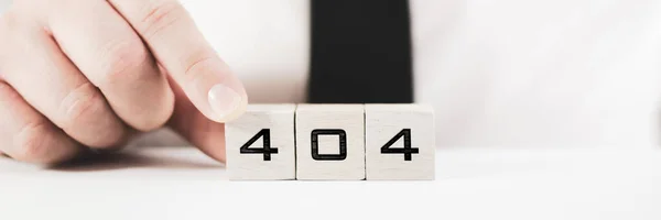 Businessperson assembling a sign 404 on white blocks in conceptual image for page not find error message
