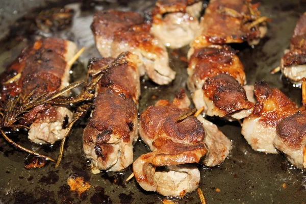 Trozos pequeños de carne envueltos cocidos en una sartén —  Fotos de Stock