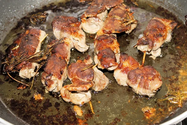 Trozos pequeños de carne envueltos cocidos en una sartén —  Fotos de Stock