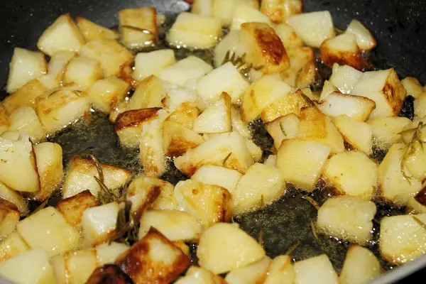 Potatoes with oil, butter, sage and rosemary for cooking in the pot — Stock Photo, Image