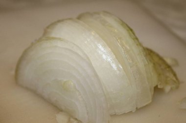 Ahşap kesme tahtası üzerinde kesilmiş soğan dilimleri