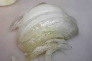 Ahşap kesme tahtası üzerinde kesilmiş soğan dilimleri