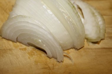 Ahşap kesme tahtası üzerinde kesilmiş soğan dilimleri