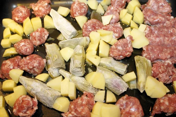 Сырая колбаса с артишоками и картошкой — стоковое фото