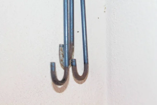 Ganchos de hierro en la pared blanca — Foto de Stock