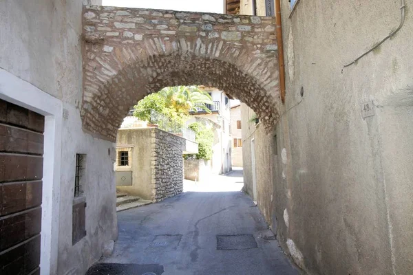 Architectonische details van een bruggetje tussen twee oude huizen in een klein dorp in Italië — Stockfoto