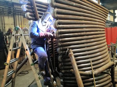 Kaynakçı koruyucu maskenin içinde bir fabrika ile iş yerinde