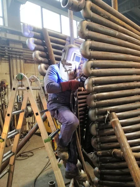 Kaynakçı koruyucu maskenin içinde bir fabrika ile iş yerinde