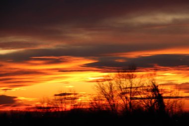 Gün batımının dramatik bulutlu gökyüzü sıcak günbatımı ışığı ile aydınlanan bulutlarla aydınlanıyor.