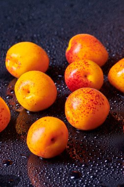 Masada su damlaları olan taze kayısılar.