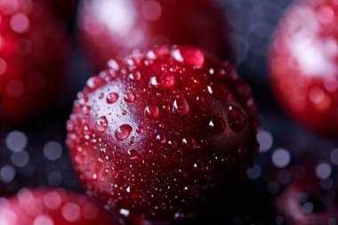 Arka planda su damlaları olan taze yıkanmış kiraz meyveleri.