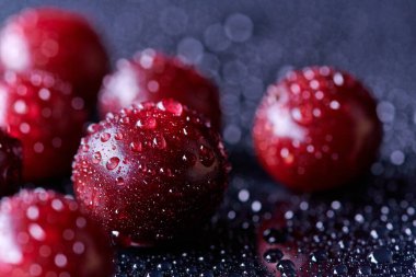 Arka planda su damlaları olan taze yıkanmış kiraz meyveleri.