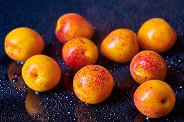 Masada su damlaları olan taze kayısılar.