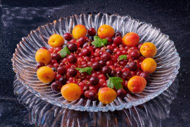 Masada su damlaları olan taze kayısılar.