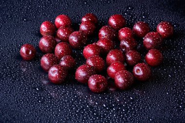 Arka planda su damlaları olan taze yıkanmış kiraz meyveleri.