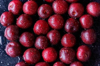 Arka planda su damlaları olan taze yıkanmış kiraz meyveleri.