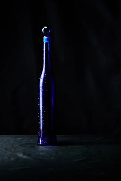 Garrafa azul elegante de presente de vinho caro com gotas de água o — Fotografia de Stock