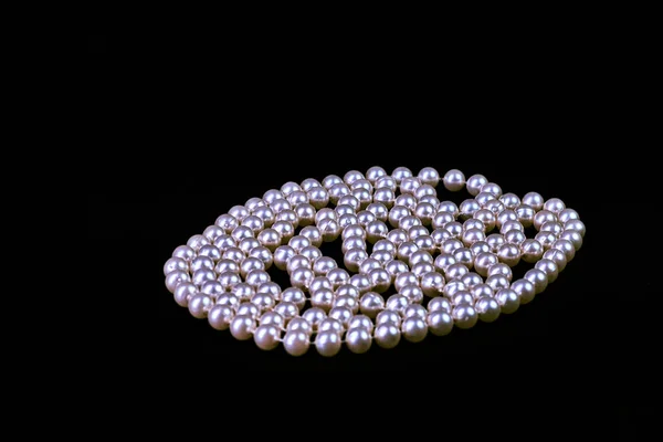 Collar de moda de perlas genuinas sobre un fondo negro es —  Fotos de Stock