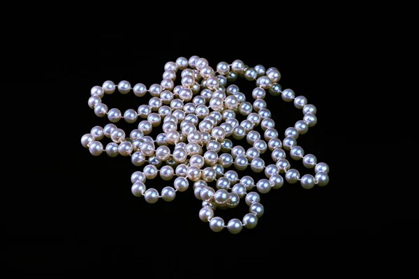 Collana alla moda di perle genuine su uno sfondo nero è — Foto Stock
