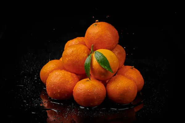 Tangerinas tangerinas com gotas de água sobre fundo preto. Novo — Fotografia de Stock